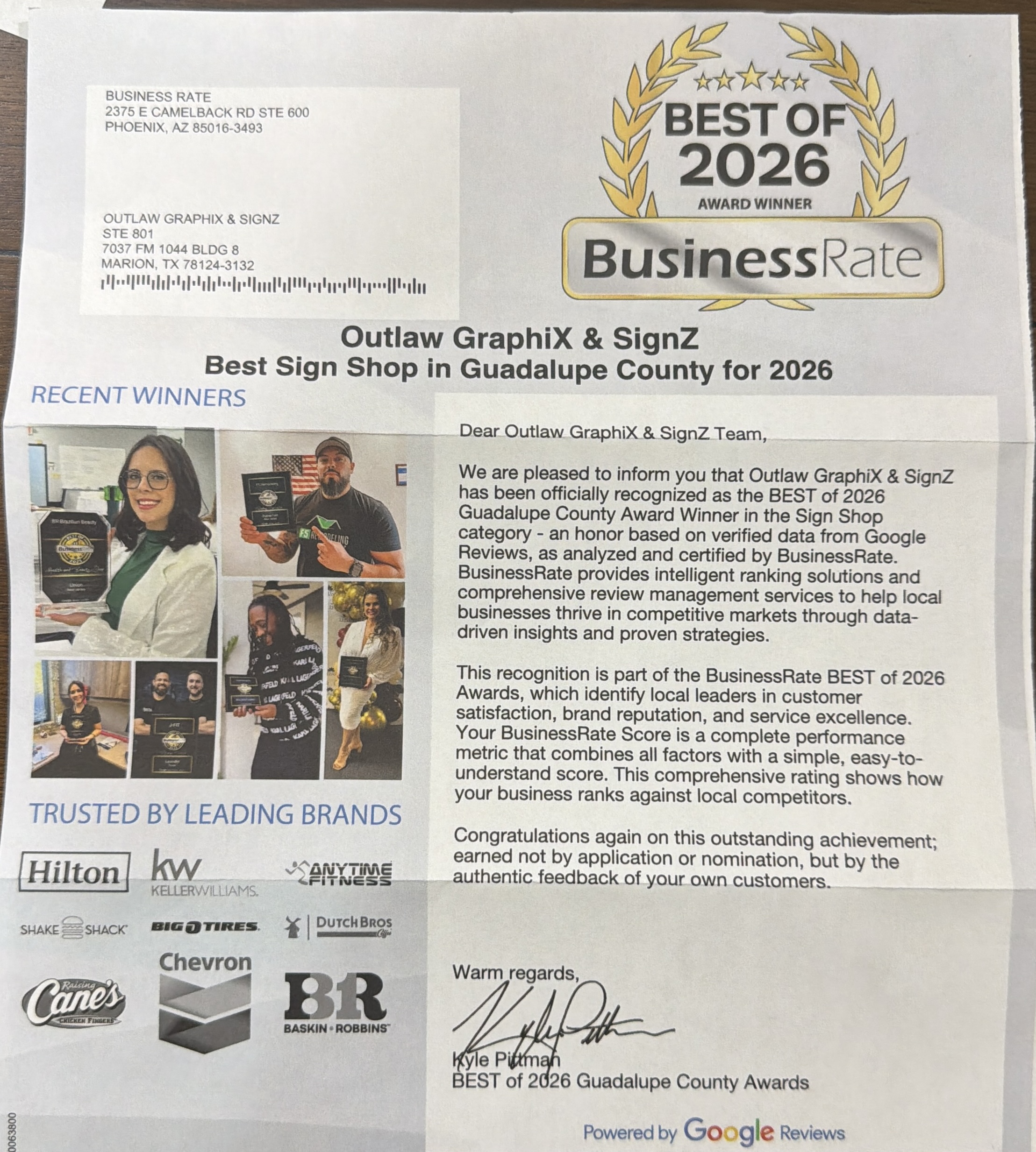 Unedited photograph of the official mailed BusinessRate Best of 2026 award letter, addressed to Outlaw GraphiX & SignZ