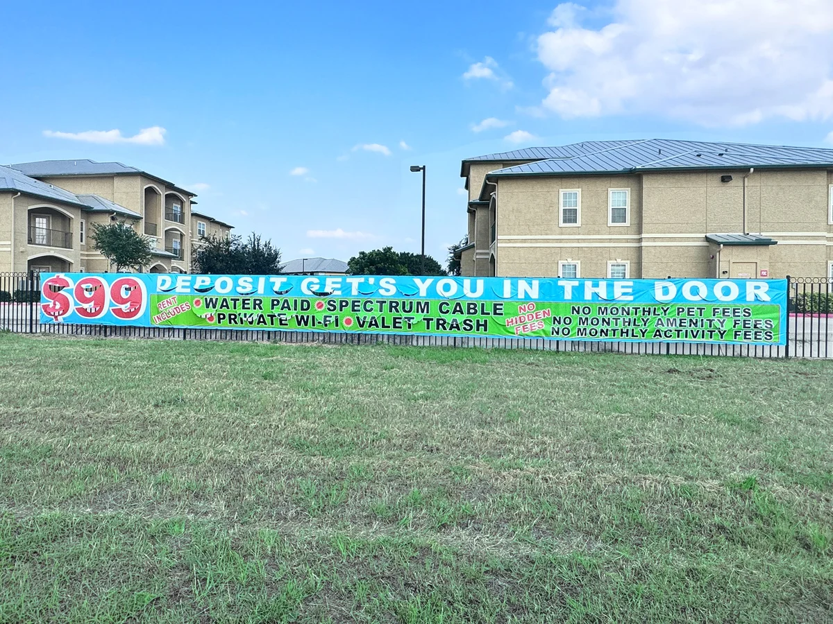 Outdoor 60-foot apartment leasing banner with $99 special pricing