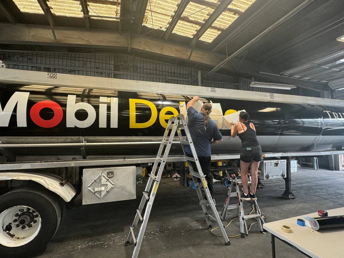 Mobil Delvac semi trailer wrap install in progress with crew