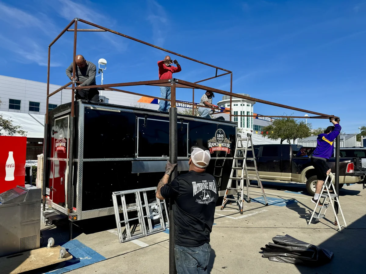 Workers on ladders installing large commercial sign